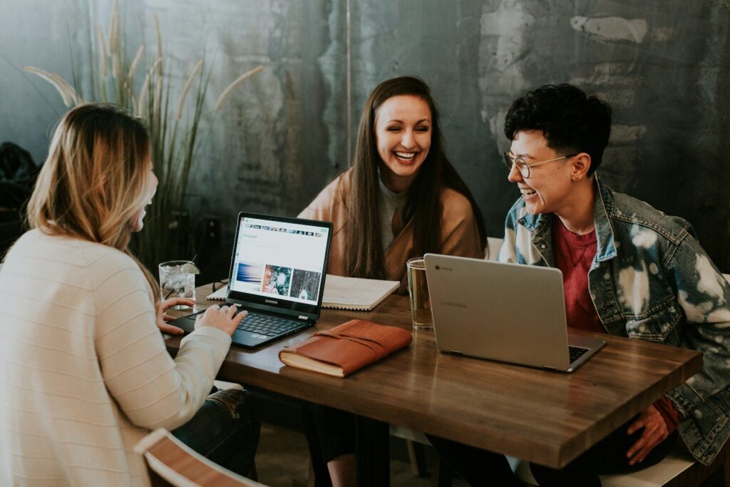 Three people learning together at laptops